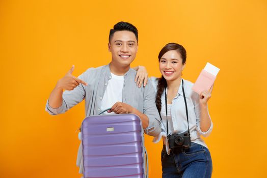 Smiling young tourists couple friends guy girl in summer clothes hat isolated on yellow background. 