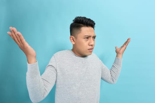 Side view of a angry man shouting and gesturing with hands isolated over blue background