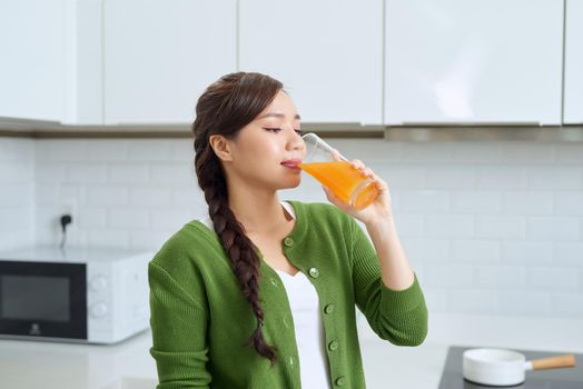 beautiful girl smiling standing hold orange glass juice kitchen