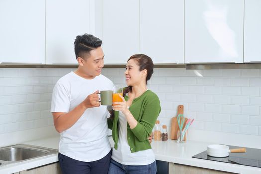 happy young couple standing in the kitchen in their house.