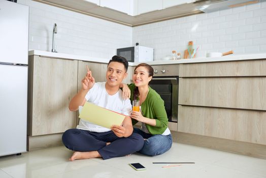 Man and woman looking at their house plans sitting in their new house