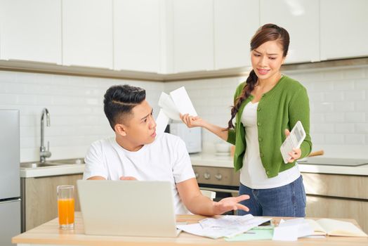 Desperate young couple with many debts reviewing their bills. Financial family problems concept.
