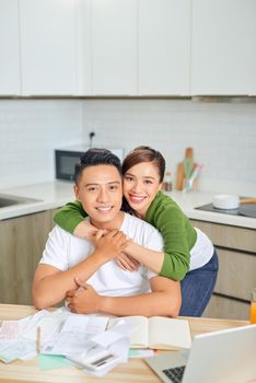 Woman and man doing paperwork together, paying taxes online on notebook pc