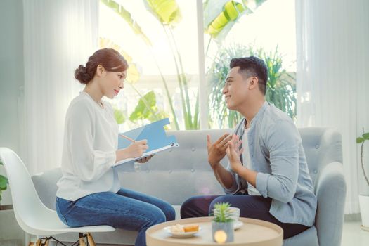 Young Asian female psychologist consulting to her client at her office.