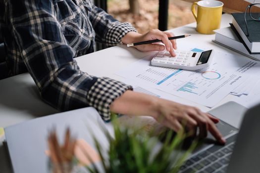 Close up woman working about financial with calculator at home office to calculate expenses, Accounting concept