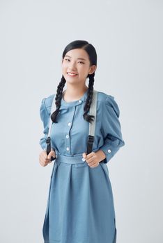 Portrait of a happy pretty girl with backpack standing isolated over white background