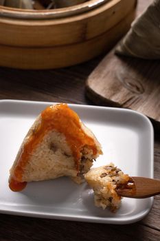 Eating Zongzi rice dumpling for Chinese traditional Dragon Boat Festival (Duanwu Festival) celebration event concept.