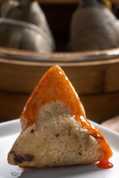 Eating Zongzi rice dumpling for Chinese traditional Dragon Boat Festival (Duanwu Festival) celebration event concept.