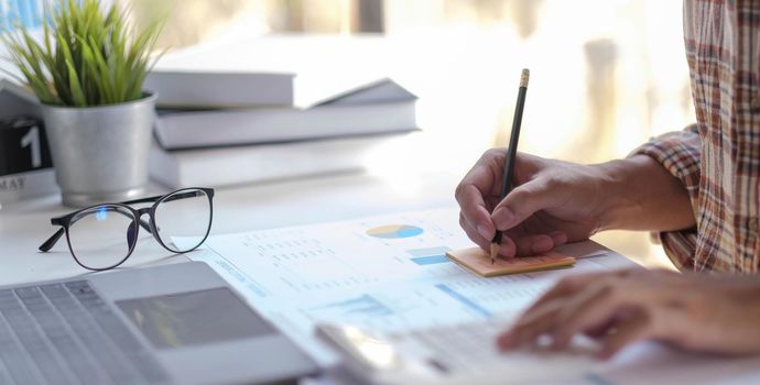 Hand man doing finances and calculate on desk about cost at home office..