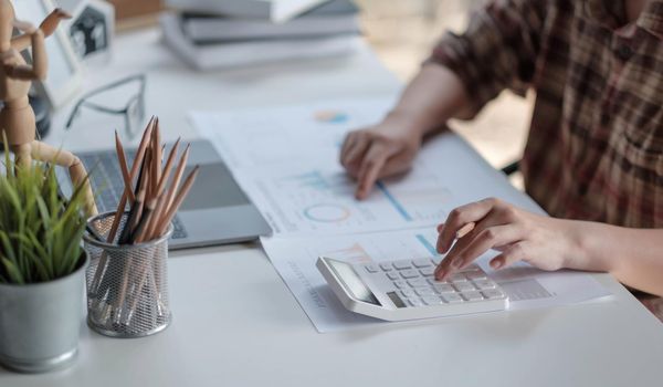 Close up woman Hands of financial manager taking notes when working on report.