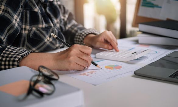 Bookkeeper or financial inspector using a calculator to calculate report profit, analyzer graph balance, tax. Business accountant concept.