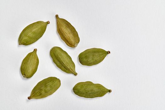 Closeup view of Green cardamom (Elettaria cardamomum) pods on a white background