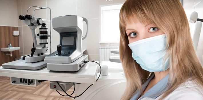 Female ophthalmologist in protective mask and whitecoat