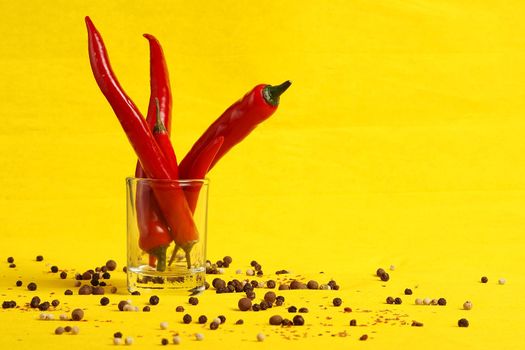 Red pepper and pepper peas on a yellow background. High quality photo