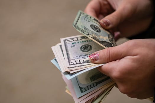 Selective focus on detail of USD banknotes. Counting or giving United States Dollars banknotes. World money concept, inflation and economy concept