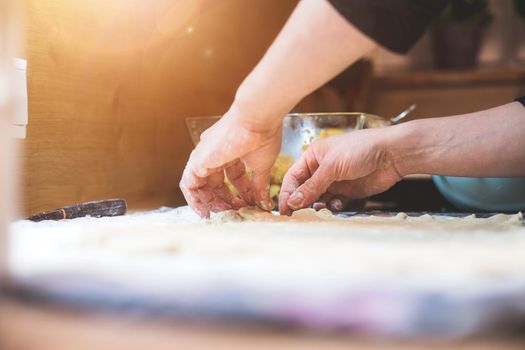 Close up of woman rolling traditional dough in the kitchen