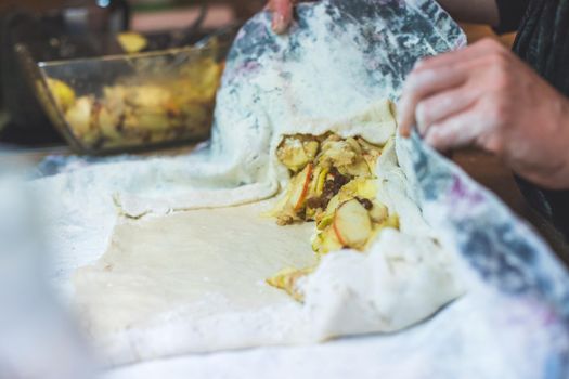 Close up of woman preparing traditional Austrian apple strudel in the kitchen