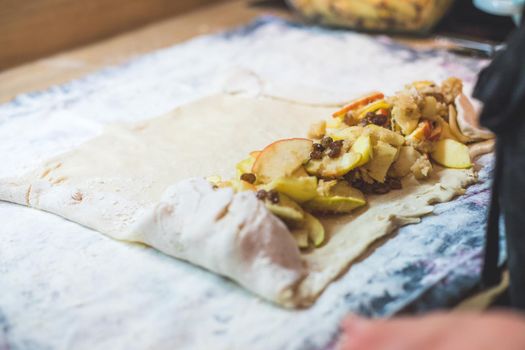 Close up of woman preparing traditional Austrian apple strudel in the kitchen