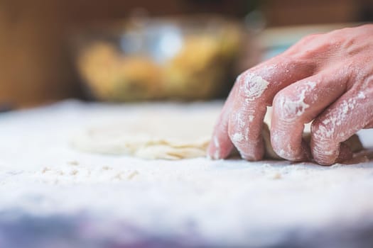 Close up of woman rolling traditional dough in the kitchen