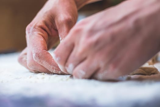 Close up of woman rolling traditional dough in the kitchen