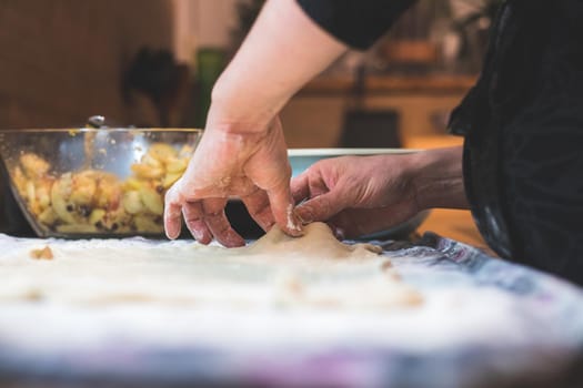 Close up of woman rolling traditional dough in the kitchen