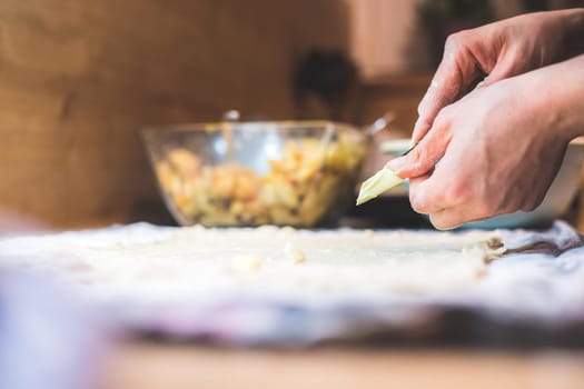 Close up of woman rolling traditional dough in the kitchen