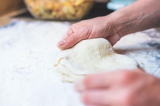 Close up of woman kneading traditional dough in the kitchen
