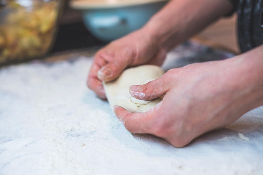 Close up of woman kneading traditional dough in the kitchen