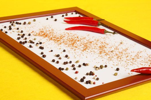 Photo frame with red chilli and spices on a yellow background. High quality photo