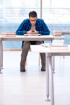 Student studying in the empty library with book preparing for exam
