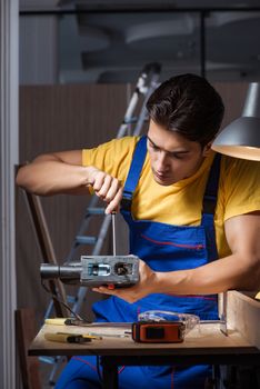 Worker working in repair workshop in woodworking concept