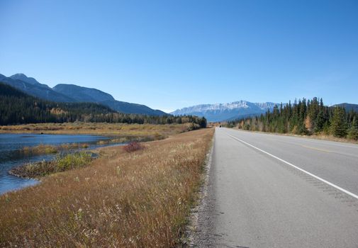 mountains behind, lake beside, the yellowhead or trans canada highway through Jasper National Park in Alberta 