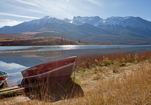  a red boat at the shoreline of Talbot Lake in Jasper National Park, Alberta