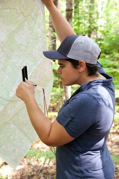 Person in the woods uses a map and compass to find their way 