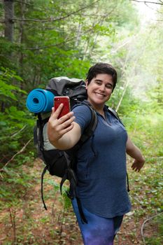  happy looking millennial poses for a selfie while showing off camping 