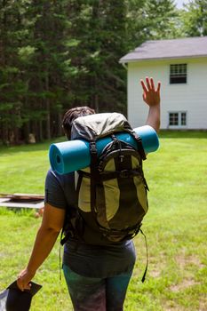 person with a backpack going hiking or camping leaving home 