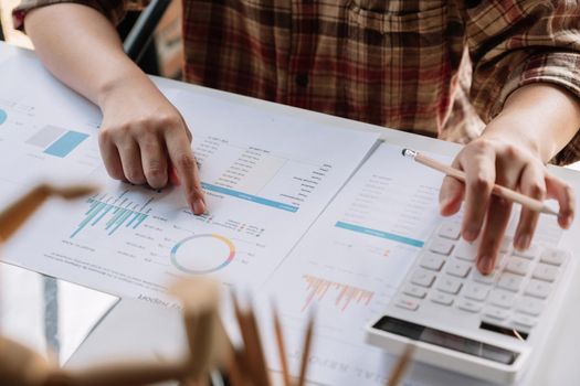 Close up hand of woman using calculator for do math finance on wooden desk in office and business working background, tax, accounting, statistics and analytic research concept