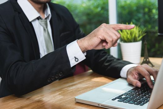 businessman close up forefinger point front monitor screen of laptop at house office