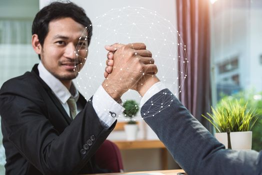 Business partners handshake shaking hands in the office with global network concept