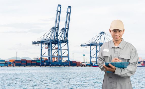 Engineer or technician write book with cargo port shipping background