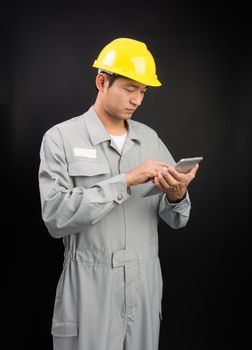 Handsome happy supervisor or technician worker with digital tablet on black background