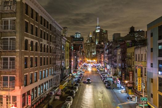 Manhattan bridge view over Chinatown at night, lower Manhattan in the background. New York City, United States of America.