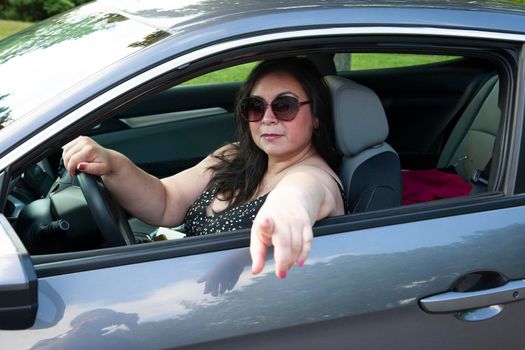 gorgeous dark haired female with sunglasses looking chill while driving her sports car 