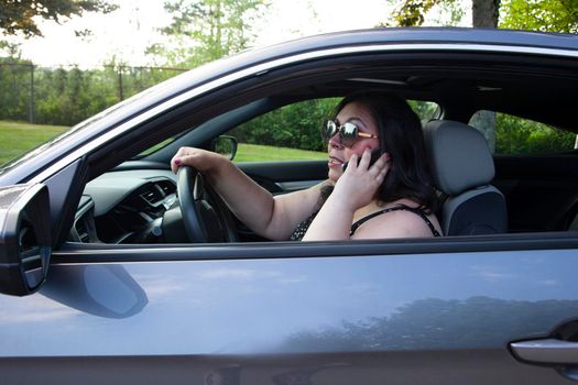 woman talking angrily on her cell phone while driving her car 