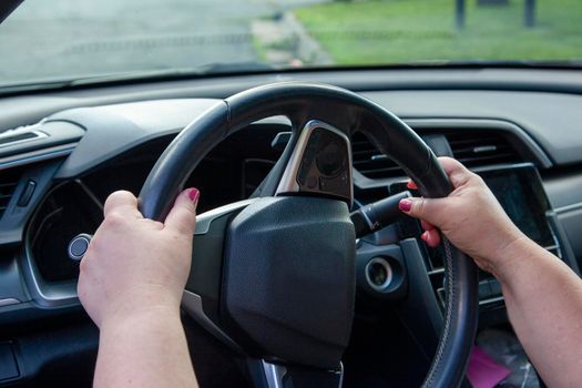 view of someone's hands on the proper position on the steering wheel while driving their car 