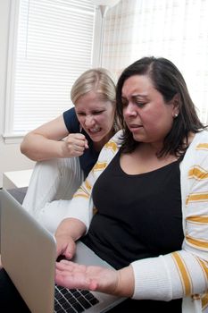 Pair or couple of women looking at computer results that make them angry