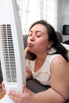 Blowing kisses into the fan that cools a person off on a hot day 