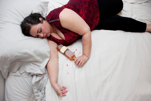 A hot mess of a woman has overdosed or passed out with her liquor 