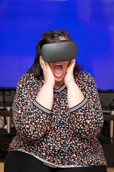 Geeky gamer is seeing a surprise or is wowed while playing virtual reality with copy space 