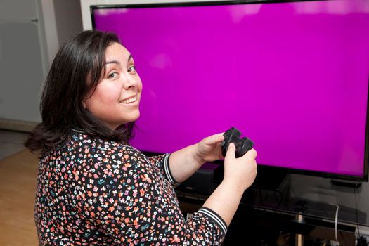 in front of a blank screen with copy space, a person is looking over their shoulder smiling while having a good time playing video games 